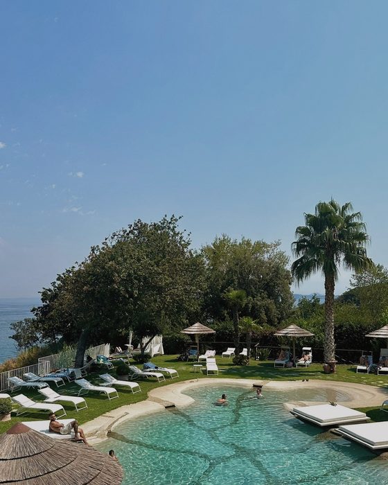 The pool above the sea, under the thatched parasols