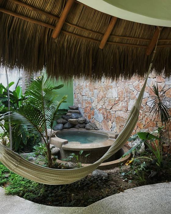The hammock strung over the rock plunge pool, under the thatch