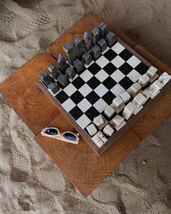 A chess set left out in the sand